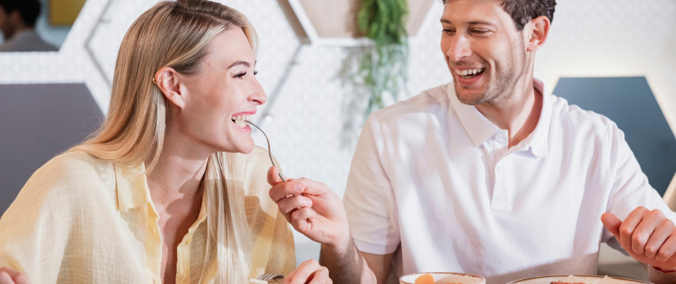 Pareja sonriendo y compartiendo un desayuno tranquilo en el restaurante del hotel